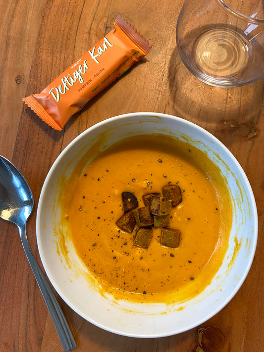 Kürbissuppe getoppt mit Kürbis-Zwiebel-Würfeln